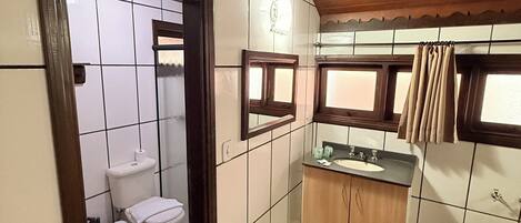 Ein kleines Badezimmer mit Toilette, Waschbecken und Spiegel.