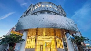Ein Hotel mit einer geschwungenen Fassade und einem großen Glas Eingang.