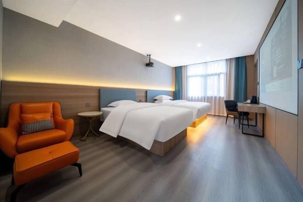 Una habitación de hotel con una cama grande, un escritorio, una silla y un sofá.