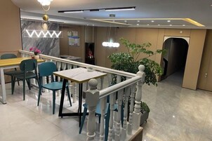 Un área de comedor moderna con encimera de mármol, sillas y barandilla.