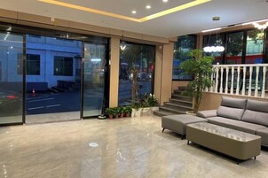 Un vestíbulo moderno con un sofá, una mesa de centro y una escalera que conduce a un área exterior.