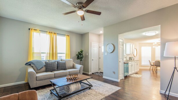 A living room with a sofa, coffee table, and a ceiling fan. - Lone Star Haven for 8 (Burleson)