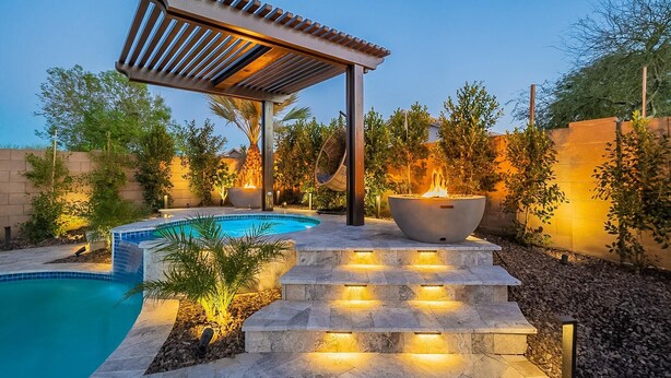 A swimming pool with a pergola and a fire pit, surrounded by steps and plants. - 7BR/4BATH Escape w/HEATED Pool, Billiards, Arcade Room, Hot Tub & Mini Golf (Peoria)