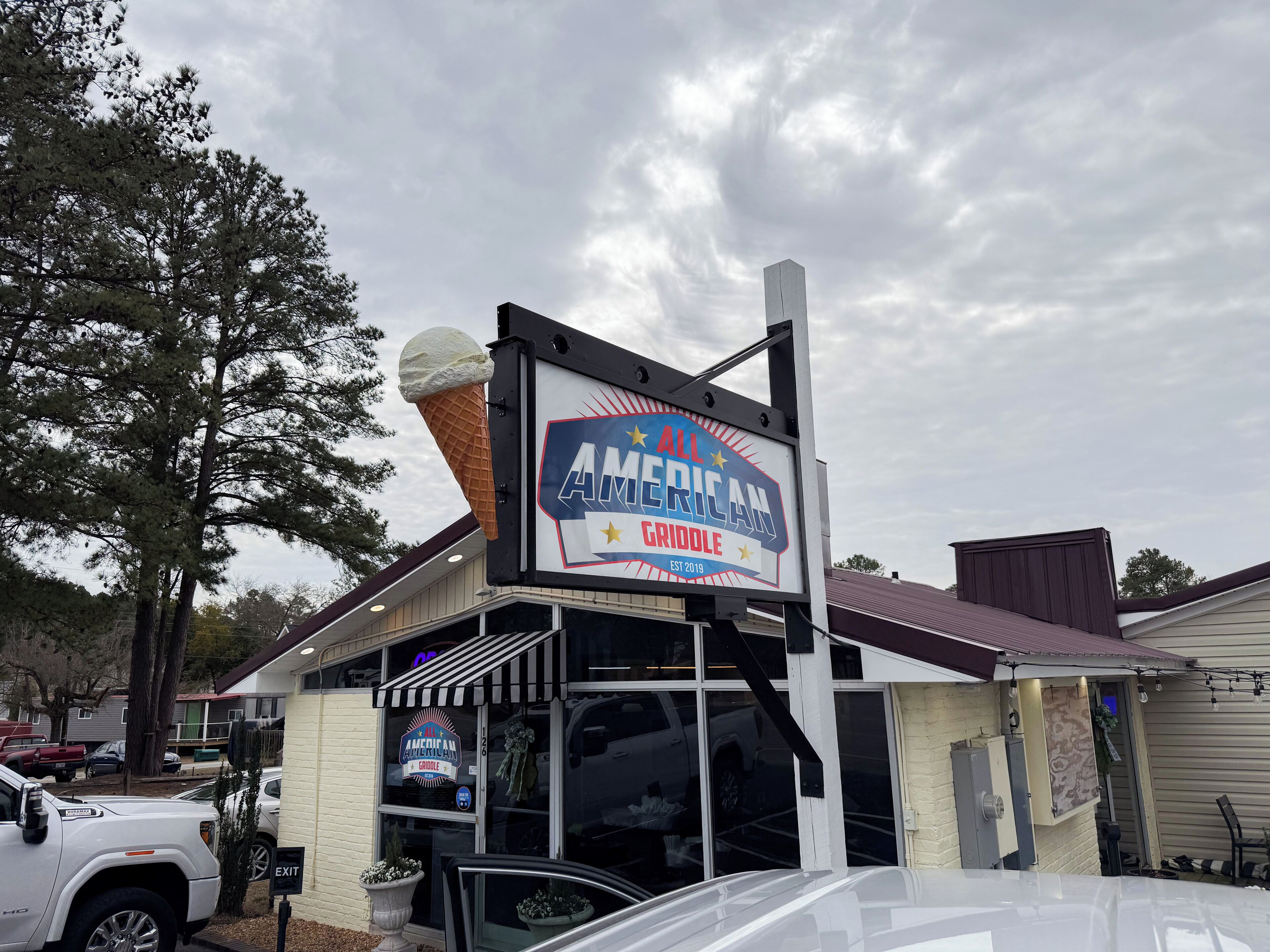 Un restaurante llamado 'American Griddle' con un cartel grande que muestra un cono de helado.