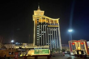 A multi-story hotel with a prominent tower and illuminated signage. - Jingman Light Luxury Hotel (Shangqiu Experimental Middle School High-speed Railway Station) (Shangqiu)