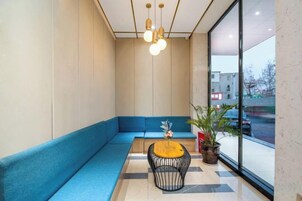 Un interior moderno con un sofá azul, una mesa redonda y una planta en maceta.