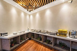 Una cocina moderna con una encimera larga, electrodomésticos integrados y plantas en macetas.