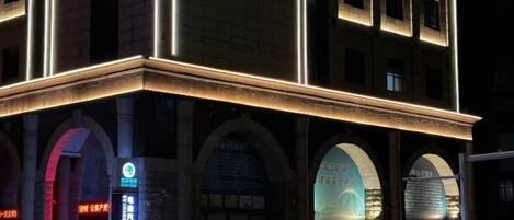 A multi-story building with illuminated signage and arched windows.