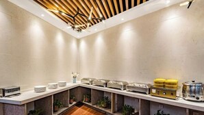 A modern breakfast bar with a wooden ceiling, marble walls, and potted plants.