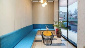 A modern interior with a blue sofa, a wooden coffee table, and a potted plant.