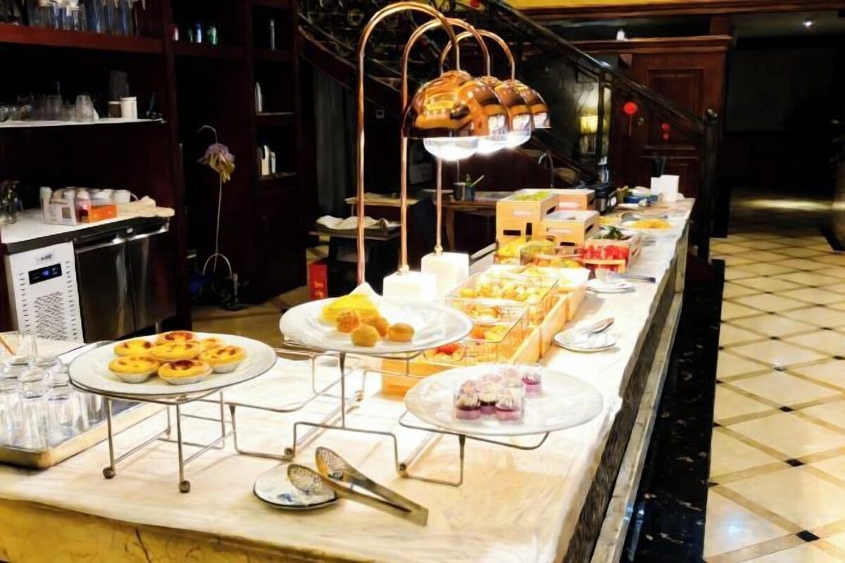 Montaje de bufé con diversos alimentos y una estación de café.