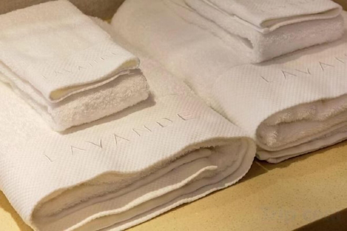 Una pila de toallas blancas dobladas con la palabra 'LAVAL' escrita en ellas.