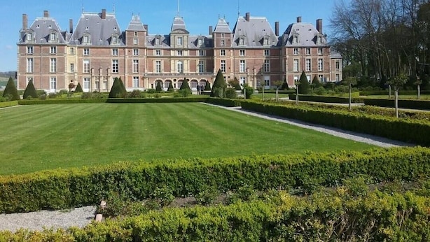 A large, historic building with a symmetrical facade, multiple chimneys, and a well-manicured lawn. - Gîtes de France® - Le Petit Marin (BRUNVILLE)