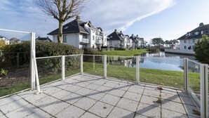 A paved outdoor area with a clear view of a residential neighborhood, including houses and a body of water. - Apartment in Middelkerke Near Beach & Pool (Middelkerke)