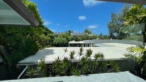 Una azotea con paneles solares, piscina y vegetación circundante.