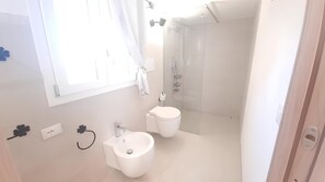 Chuveiro, secador de cabelo, bidê, toalhas de banho