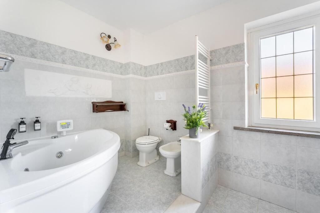 A modern bathroom with a freestanding bathtub, a toilet, and a bidet.