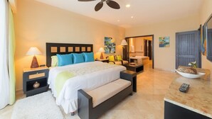 A hotel room with a large bed, bedside tables, a ceiling fan, and a bathroom visible through an open door.