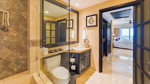 A modern bathroom with a glass shower enclosure, a large mirror, a vanity with a sink, and a toilet.