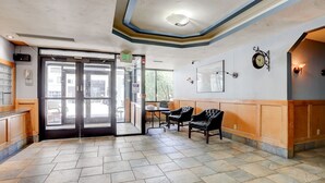A lobby with a tiled floor, a reception desk, a clock, and a seating area. - Charming 1BR Retreat in Denver (Denver)