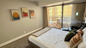 A bedroom with a large bed, a view of the outside, and two wall art pieces. - Charming 1BR Retreat in Denver (Denver)