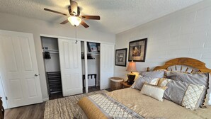A bedroom with a bed, a ceiling fan, a nightstand with a lamp, a bedside table, a wardrobe, and a closet. - Charming furnished 2-bedroom, 1 bath apartment with WiFi, AC in lovely Kalispell (Kalispell)