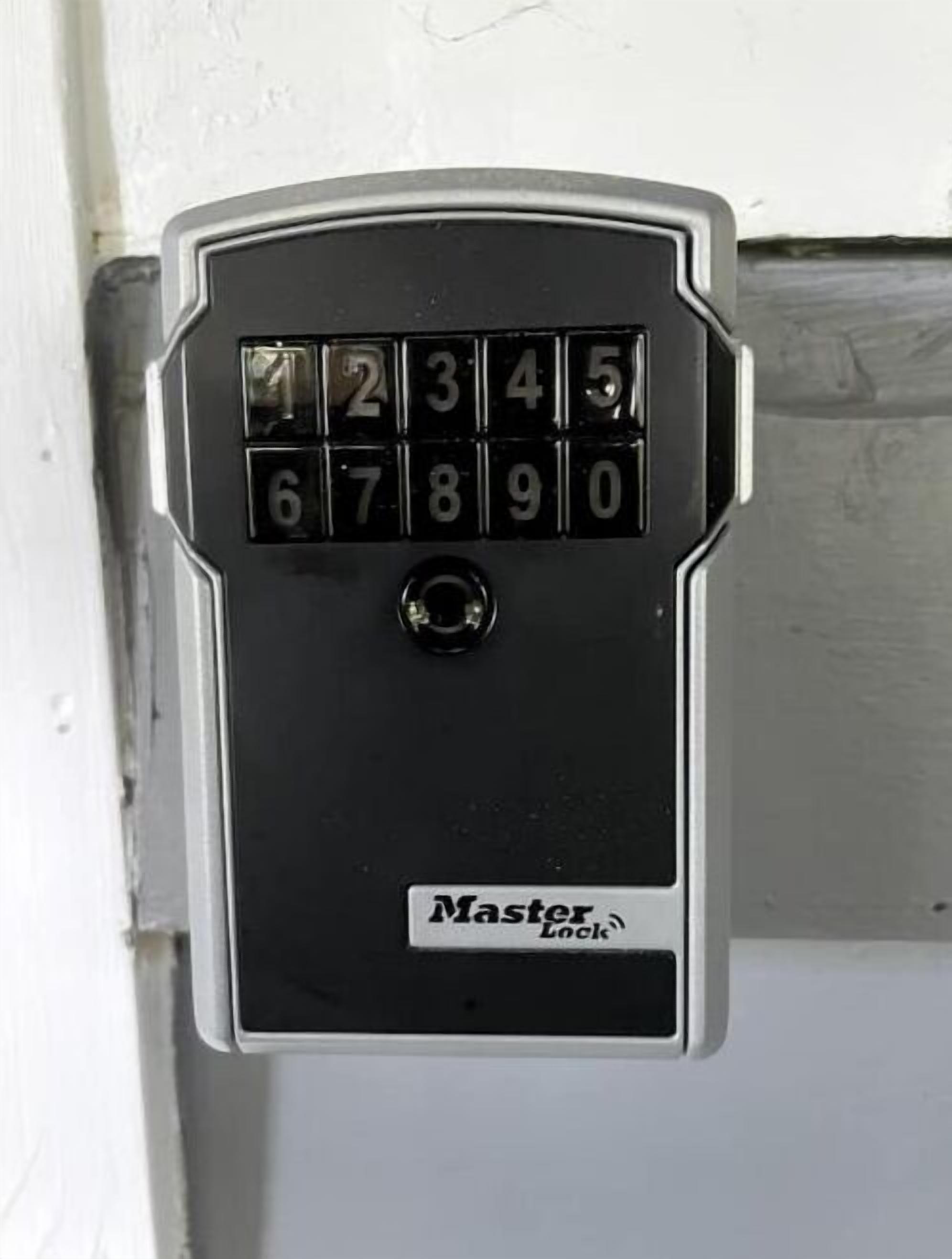 A black Master Lock keypad with numbers 0-9 and a central button.