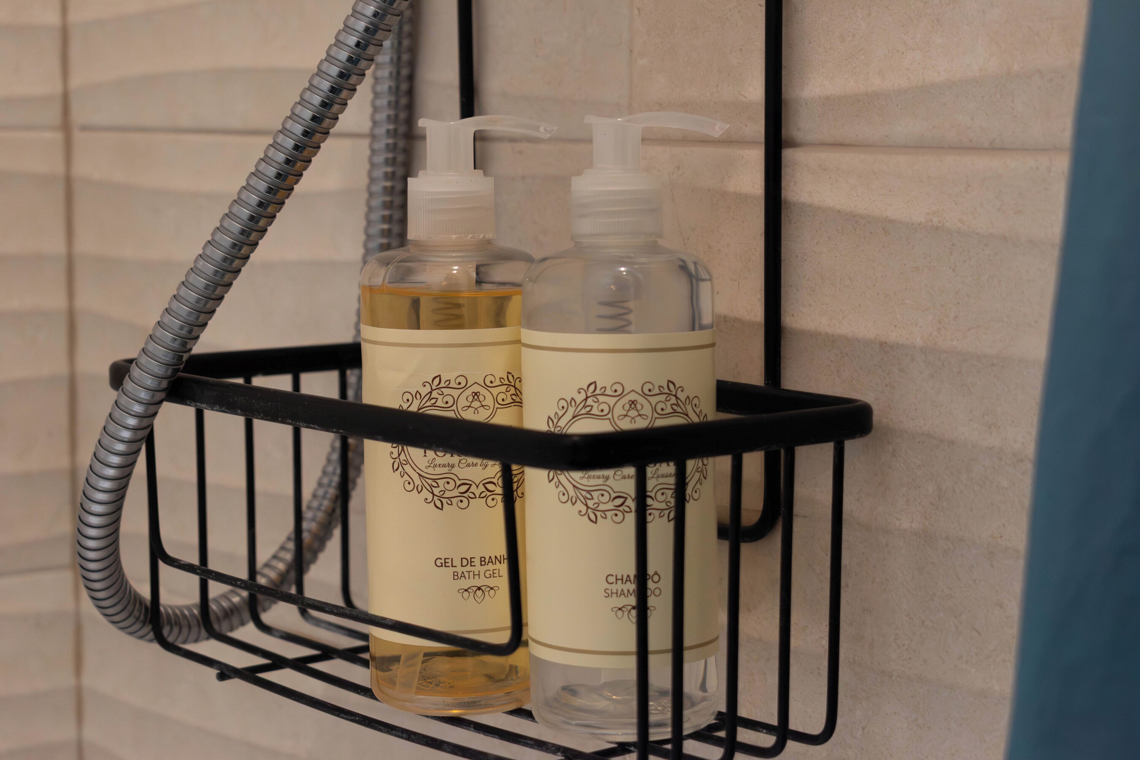 Un estante de baño con dos botellas de gel de baño y champú.