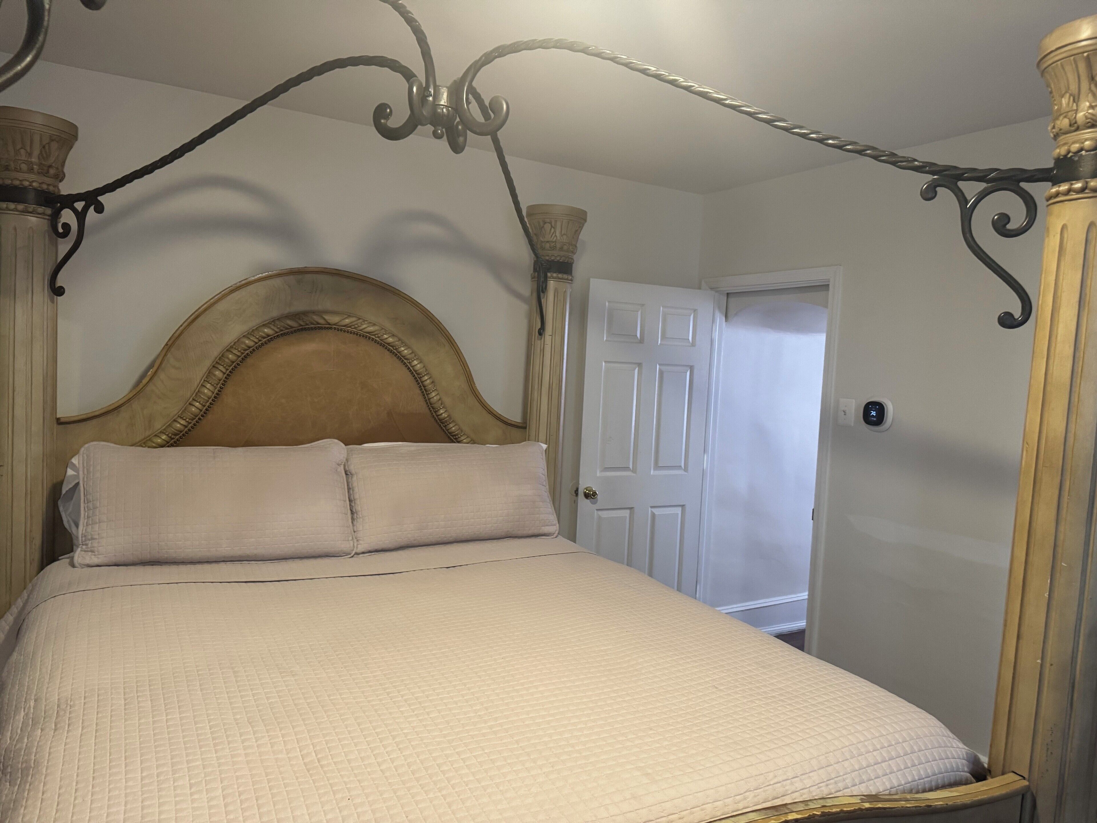 Een bed met hoofdeinde, een deur en een muur.