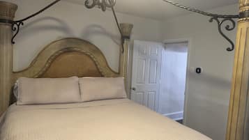 Een bed met hoofdeinde, een deur en een muur.