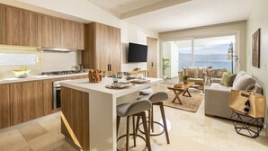 Una cocina moderna con armarios de madera, una isla central y una zona de comedor con taburetes de bar.
