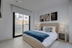 A modern bedroom with a large bed, a nightstand, and a window with a view of a building. - ViVi Homes pool, Bossa nova apartment (Fuengirola)