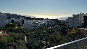 A coastal residential area with modern buildings, a clear sky, and a view of the sea. - Bossa Nova | pool - terrace - fuengirola (Fuengirola)