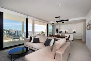 Ein modernes Wohnzimmer mit einer Couch, einem Couchtisch und Blick auf die Stadt.
