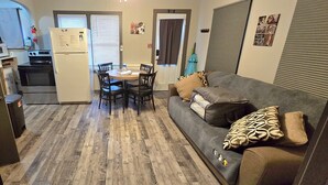 A compact living space with a kitchenette, a dining area, and a sofa with decorative pillows. - "Oreo’s Dream – A Cozy, Dog-Lover’s Retreat!" (Geneva)