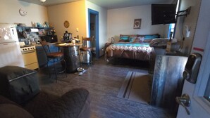 Un espacio habitable compacto con kitchenette, comedor, cama y baño.