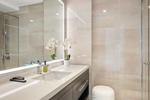 Ein modernes Badezimmer mit großem Spiegel, Waschbecken und Toilette.