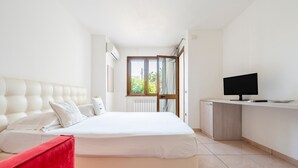 Un dormitorio con cama, televisión y ventana.