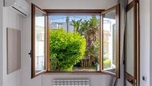 Una habitación con un ventanal grande, un aire acondicionado y un radiador.