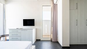 Una habitación de hotel con cama, televisión, escritorio y armario.