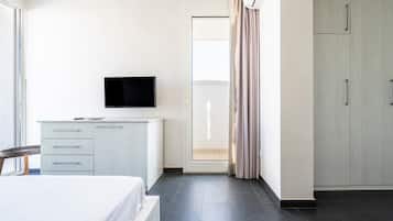 A hotel room with a bed, a TV, a desk, and a wardrobe.