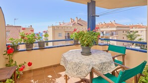 A balcony with a table and chairs, potted plants, and a view of buildings. - Apartment 'Argia' with Sea View, Wi-Fi, and Air Conditioning (Algarrobo)