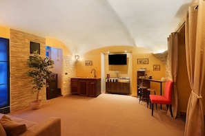 Una sala de estar acogedora con chimenea, comedor y cocina con televisor.