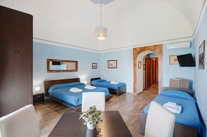 A hotel room with two beds, a dining table, a plant, and a TV. - Room 'Maruzzella' with Shared Terrace, Wi-Fi and Air Conditioning (Meta)