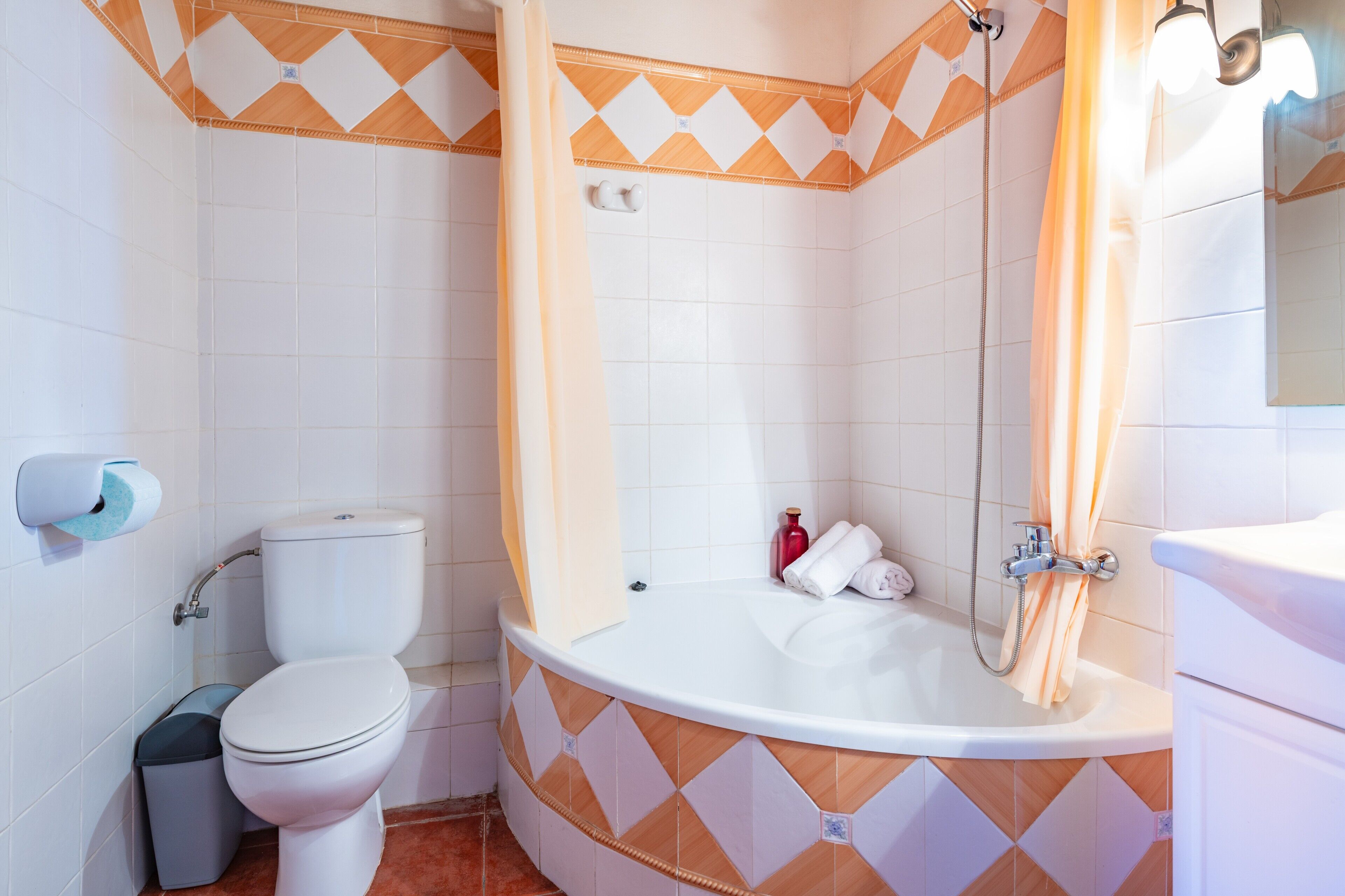 Un baño con inodoro, bañera y cortina de ducha.