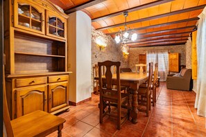A dining area with wooden furniture, stone walls, and a chandelier. - Country House 'Virginia' with Mountain View and Balcony (Unknown)