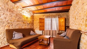 A stone-walled room with two brown sofas, a wooden coffee table, and a wooden cabinet. - Country House 'Virginia' with Mountain View and Balcony (Unknown)