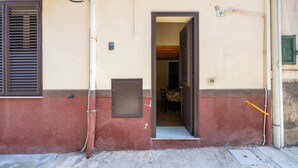 A building entrance with a door, a window with blinds, and a visible number plate. - Holiday Home 'Zaami' with Sea View, Wi-Fi and Air Conditioning (Palermo)
