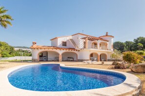 A Mediterranean-style villa with a swimming pool, outdoor seating, and a garden. - Villa 'Merced' with Mountain View, Private Pool and Wi-Fi (Calpe)