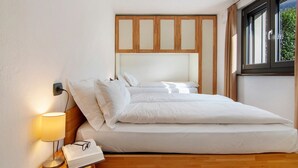 A bedroom with a bed, bedside lamp, and a window. - Apartment 'Il Nido Del Lago' with Sea View, Wi-Fi and Air Conditioning (Colico Piano)